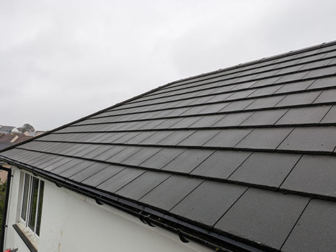 a clean black roof on a white painted house